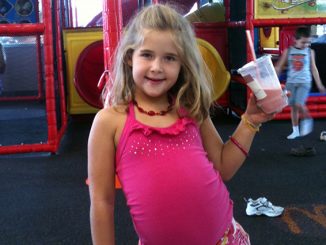 Photo of Annabel Beam holding milkshake at playground. Beam claims she's been to heaven.